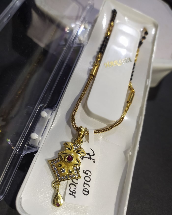 Kemp Patra Chain, Kite-shaped textured gold pendant with a ruby cabochon and drop