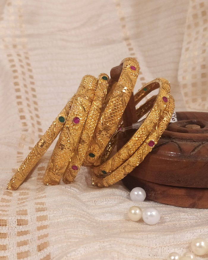 Kemp Nakshi Bangadi, Nakshi-carved bangle fan of seven, alternating ruby and emerald cabochons